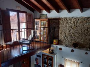 a living room with a staircase and a stone wall at Casa Rural La Rocha in Chulilla