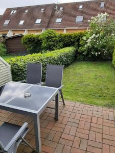 a white table and two chairs on a patio at Beiboot in Wangerland