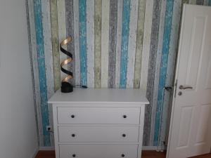 a white dresser with a vase on top of it at Beiboot in Wangerland