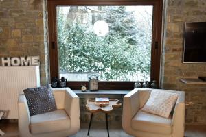 ein Wohnzimmer mit 2 Stühlen und einem großen Fenster in der Unterkunft Pefkofyto Mountain Retreat in Pefkófyton