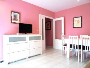 ein Wohnzimmer mit rosa Wänden und einem TV auf einer Kommode in der Unterkunft Las Nereidas LEK in Peñíscola