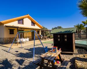 a playground with a swing and a house at Cubo's Casa Rural Mirador de Bolaño in Cártama