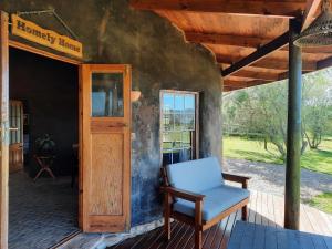 una silla sentada en el porche de una casa en The Funny Farm Shire, en Duiwerivier