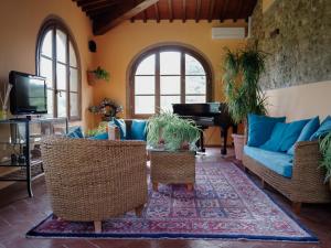 ein Wohnzimmer mit blauen Sofas und einem Klavier in der Unterkunft Torre di Polvereto in Montespertoli