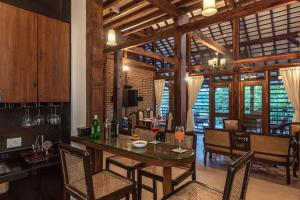 a kitchen and dining room with a table and chairs at SaffronStays Vedika - EcoFriendly villa by the River with Pool in Pālghar