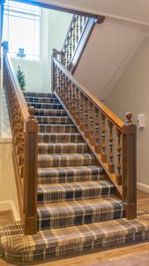 a staircase in a house with a plaid carpet at West End Hotel in Nairn