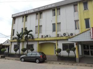 une voiture garée devant un bâtiment dans l'établissement HOTEL SAFFANA, à Douala