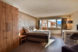 ein Schlafzimmer mit einem Bett, einem Schreibtisch und einem Fenster in der Unterkunft Rhodania 56 in Riederalp + 10 Fotos