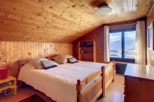 ヴェルビエにあるClochard Céleste Comblesの木造キャビン内のベッド1台が備わるベッドルーム1室を利用します。