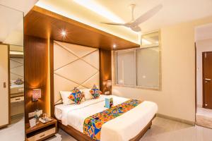 a bedroom with a large bed and a ceiling fan at FabHotel Spring Inn Kandivali in Mumbai