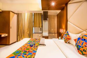 a bedroom with a large bed with a colorful bedspread at FabHotel Spring Inn Kandivali in Mumbai