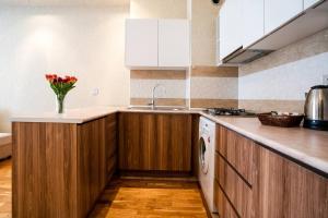 a kitchen with wooden cabinets and a vase of flowers on the counter at Kristal Absheron in Baku