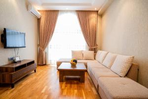 a living room with a couch and a tv at Kristal Absheron in Baku