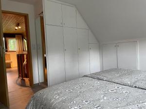 a bedroom with white cabinets and a bed at Ferienwohnung Hemmerle in Bispingen