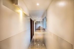a hallway with white walls and a long corridor at FabHotel Spring Inn Kandivali in Mumbai