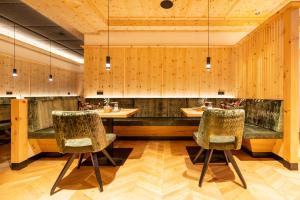 ハインツェンベルクにあるFerienhotel Jörglerhofの木製の壁とテーブルと椅子2脚が備わるレストランを併設しています。