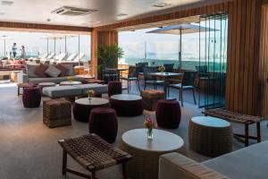 a hotel lobby with tables and chairs and windows at PortoBay Rio de Janeiro in Rio de Janeiro