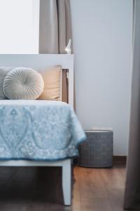 um quarto com uma cama com um cobertor azul em Neringarent Apartamentai em Juodkrantė