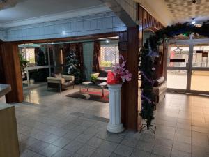 un hall avec une couronne de Noël et une colonne fleurie dans l'établissement HOTEL SAFFANA, à Douala