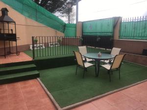 un patio con mesa, sillas y una valla en Casa Rural cueva cerros en Fuentidueña de Tajo