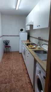 a kitchen with a sink and a washing machine at Casa Rural cueva cerros in Fuentidueña de Tajo