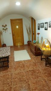 a living room with a large tile floor and a wooden door at Casa Rural cueva cerros in Fuentidueña de Tajo
