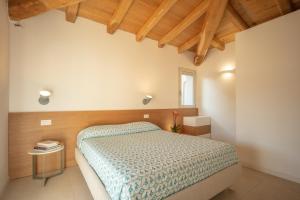 1 dormitorio con cama y techo de madera en Domu Simius Hotel, en Villasimius