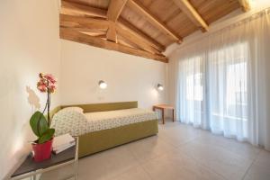 a bedroom with a bed and a large window at Domu Simius Hotel in Villasimius