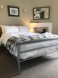 a bedroom with a bed and a dresser at Ivy Braveheart Guest House in Edinburgh