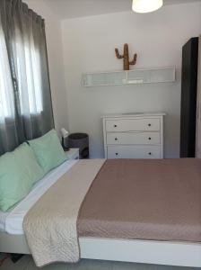 Un dormitorio con una cama y una cruz en un estante en Home Away From Home, en Ixia