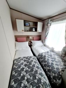 a small bedroom with two beds in a trailer at Robin Hood's Retreat in Robin Hood's Bay