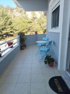 balcón con mesa azul y ventana en Home Away From Home, en Ixia