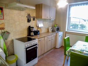 a small kitchen with a stove and a microwave at Ferienwohnung Gluehwuermchen in Barnin