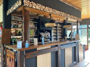 un bar con barra de madera con botellas de alcohol en Village Club Les Cîmes du Léman-Neaclub, en Habère-Poche