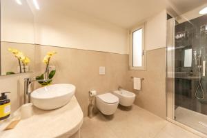uma casa de banho com um lavatório, um WC e um chuveiro em Domu Simius Hotel em Villasimius