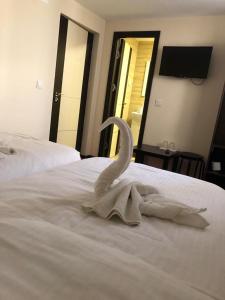 Un cisne hecho de toallas en una cama en Casa Adrian, en Hîrşova 1 foto más