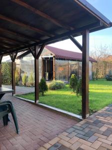 - un pavillon avec une table et un banc sur une terrasse en briques dans l'établissement Casa Adrian, à Hîrşova