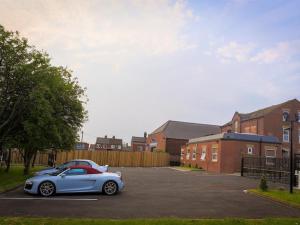 a silver car parked in a parking lot at Spacious Apartment Sleep 6 in Leeds