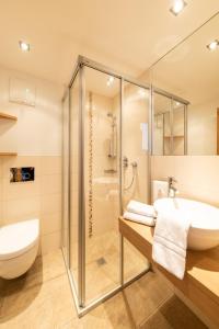 a bathroom with a glass shower and a sink at Der Winklhof in Saalfelden am Steinernen Meer +37 photos