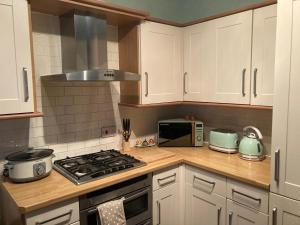 a kitchen with a stove top oven next to a microwave at Bedford House Retreat in Scarborough