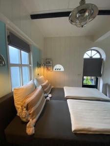 カンペルラントにあるHet Koetshuisのベッド2台と窓が備わる客室です。