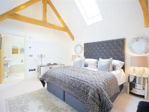 a bedroom with a large bed with a blue headboard at The Hive in Stow on the Wold