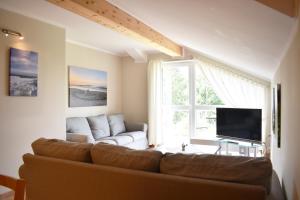 a living room with a couch and a large window at Usedom Landhaus Morgenitz in Morgenitz