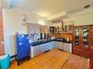 a large kitchen with a blue island in a room at Mysa by Meraki - Entire Villa with Himalayan Views in Rānīkhet