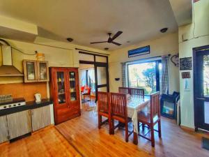 a kitchen and dining room with a table and chairs at Mysa by Meraki - Entire Villa with Himalayan Views in Rānīkhet
