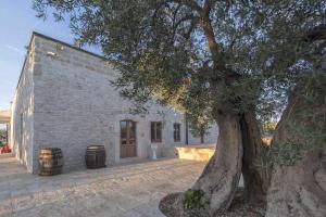 een gebouw met een boom ervoor bij Masseria Fanizzi in Conversano