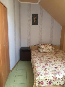 a bedroom with a bed with a floral bedspread at v LAD i MIR Guesthouse in Zatoka