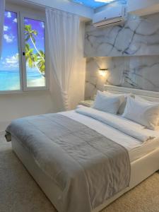 a bedroom with a bed with a view of the ocean at "Serenity Premium apartments" с панорамным видом на море in Sochi