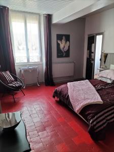 sypialnia z łóżkiem i czerwoną podłogą wyłożoną kafelkami w obiekcie Marie-Claire la grillade w mieście Briare