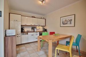 eine Küche mit einem Holztisch und Stühlen in der Unterkunft Moderne Strandvilla Moderne Strandvilla Appartement 2 in Timmendorfer Strand
